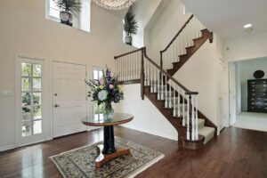 Dark hardwood flooring in a traditional home entryway with staircase and foyer table | The Carpet Stop