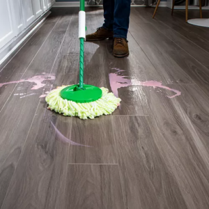 Dark wood-look flooring being cleaned after a spill with a mop | The Carpet Stop