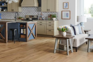 Warm wood flooring in an open-concept kitchen and living room with comfortable seating | The Carpet Stop